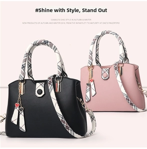 Close-up of black and pink leather handbags with plaid fabric handles and heart charms