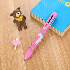 Süßer rosa 6-farbiger Einhorn-Kugelschreiber für Schüler auf Holztisch mit Notizbuch