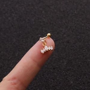 Detail showing a small gold piercing stud with five hanging teardrop-shaped zircons