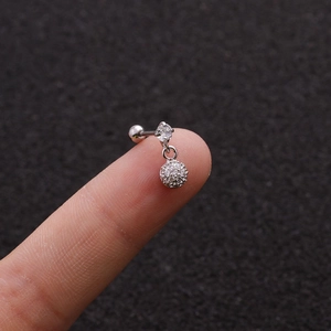 Macro shot of a silver piercing stud with micro-pave cubic zirconia on a fingertip