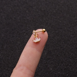 Macro view of gold crown piercing stud with micro-pave zircon on fingertip