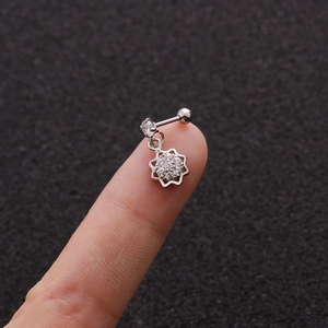 Close-up of stainless steel flower stud earring with zircons held on a finger for scale