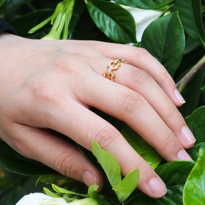 Detail of rose gold chain link ring with sparkling zircon stones on model's hand