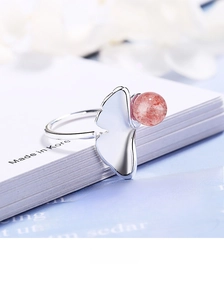 Detailansicht des silbernen Ginkgo-Rings mit rosa Quarz auf einem Notizbuch