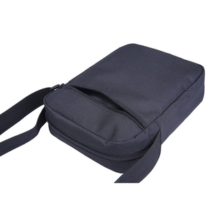 Detail view of the black canvas crossbody bag with adjustable strap and dual zipper pockets