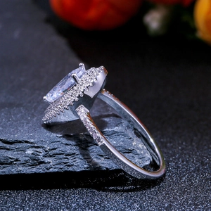 Macro side view of marquise-cut zircon ring with double halo on dark stone base
