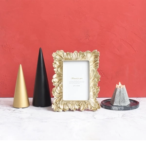 Detailed close-up of golden photo frame with embossed leaf patterns on red background