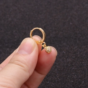 Detailed close-up of a gold sunflower earring with cubic zirconia held by hand