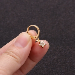 Close-up of hand holding a gold star charm hoop earring with sparkling zircon details
