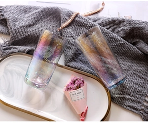Detailed hammered texture on rainbow crystal glass cups set on a white gold-edged tray