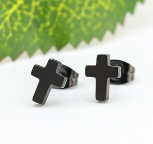 Close-up of minimalist black stainless steel cross earrings on a clean white surface