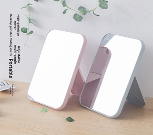 Detail showing adjustable folding stands of pink and grey portable desktop mirrors