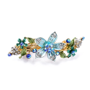 Elegant gold hair clip with blue floral enamel patterns and sparkling rhinestones