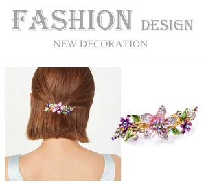 Close-up of pink and purple floral hair clip with crystals and golden metal finish
