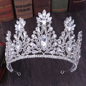 Close-up of silver princess crown with crystals and rhinestones on vintage wood surface
