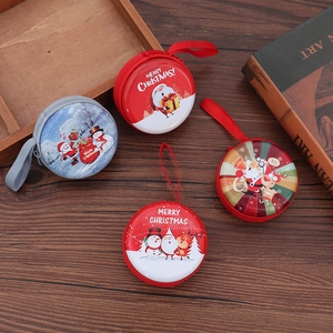 Round tinplate Christmas coin purses with festive Santa and Snowman prints on wood
