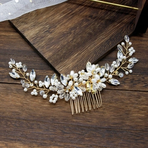Detail of bridal hair comb with pearls and marquise crystals on a vintage wood surface