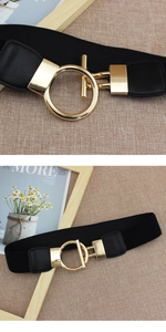 Détail de la boucle dorée ronde sur une ceinture élastique noire en cuir PU pour femme
