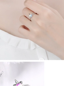 Macro detail of silver unicorn cat ring featuring a pearlescent rainbow moonstone