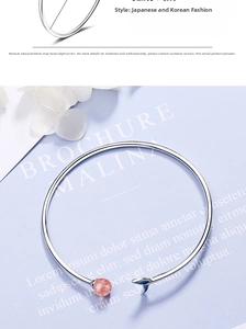 Detail of silver fish tail cuff bracelet featuring a pink strawberry quartz bead charm