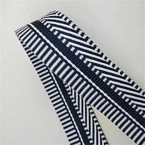 Close-up of wide woven bag strap with navy and white geometric herringbone patterns