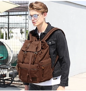 Outdoor shot of a vintage dark brown canvas backpack featuring premium leather straps