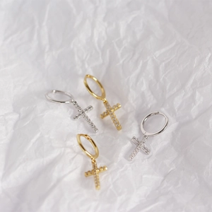 Close-up of S925 silver hoop earrings with sparkling diamond-set cross charms in gold and silver