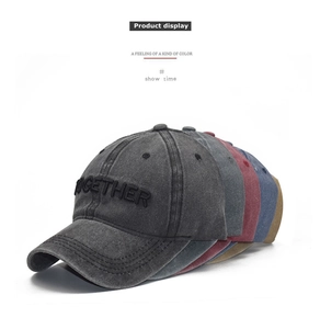 Pile of washed cotton baseball caps with 3D Together embroidery in multiple colors