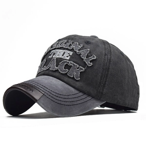 Detail of embroidery on washed cotton baseball cap with brown leather brim accents