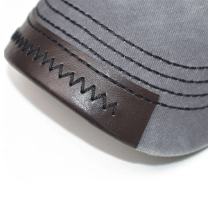 Macro detail of high-quality contrast stitching and leather trim on a vintage baseball cap