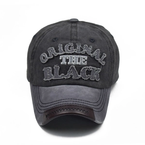 Close-up of vintage washed cotton baseball cap with embroidered BLACK patch and leather trim