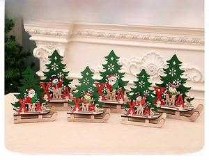 Détail d'un traîneau de Noël en bois avec sapin découpé et figurines de Père Noël