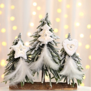 Three flocked Christmas trees with white feathers and star ornaments on wooden bases