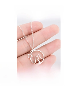 Close-up of minimalist cat and star pendant necklace held in hand to show size