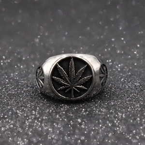 Macro detail of silver stainless steel ring featuring engraved hollow leaf patterns