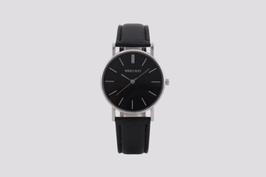 Detail view of the black watch face with silver case and minimalist linear markers