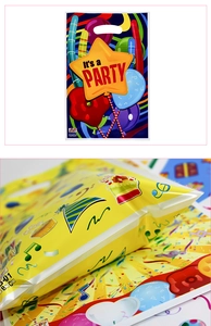 Detail of gusseted bottom and die-cut handle on colorful plastic birthday party gift bags