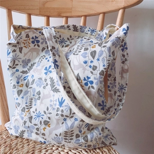 Detail of floral and elk pattern on off-white cotton tote bag with soft inner lining