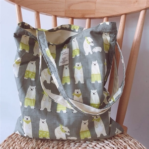 Detail of grey cotton canvas tote bag with polar bear print on a wooden chair
