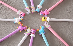 Vista dettagliata dall'alto di penne gel luminose con unicorno e orso disposte a cerchio