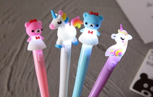 Primo piano di quattro penne LED luminose con orsetti e unicorni in colori vivaci e brillanti