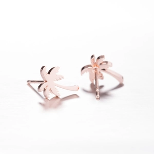Elegant rose gold palm tree stud earrings made of stainless steel on white background