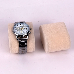 Macro di un orologio cronografo d'argento su un cuscino da esposizione beige
