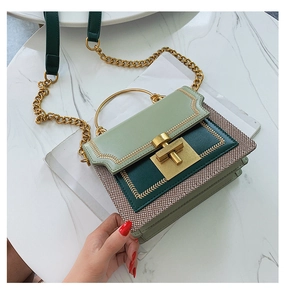 Detail of green leather and woven fabric crossbody bag with chain and metal handle