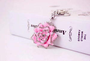 Macro detail of a pink rose keychain with sparkling rhinestones and silver-tone metal chain