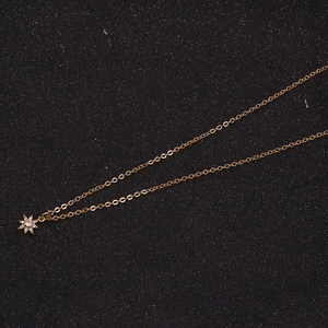 Elegant gold necklace with sparkling eight-pointed star pendant on black starry background