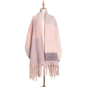 Close-up of pink and beige plaid scarf with soft fringe tassels and woven texture
