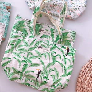 Detailed flat lay of cotton canvas bags with tropical toucan and floral animal prints