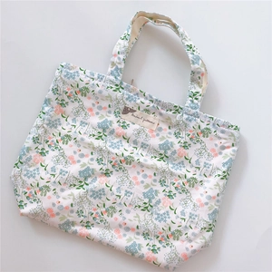 Detailed close-up of a floral cotton handbag with blue flower patterns and label