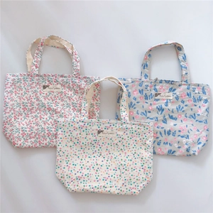 Flat lay of three cotton canvas handbags with floral and polka dot patterns and zipper